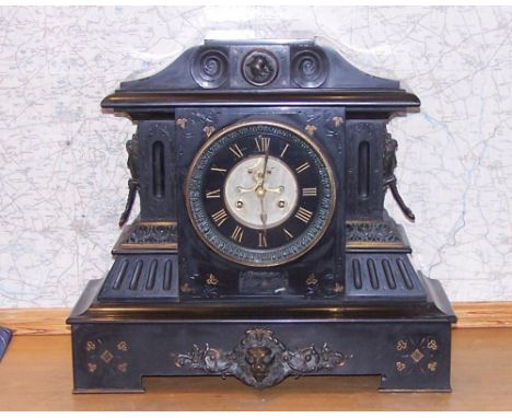 A large Victorian Mantle Clock with black dial and in black marble case with classical decoration and mask handles, 18" (46cm