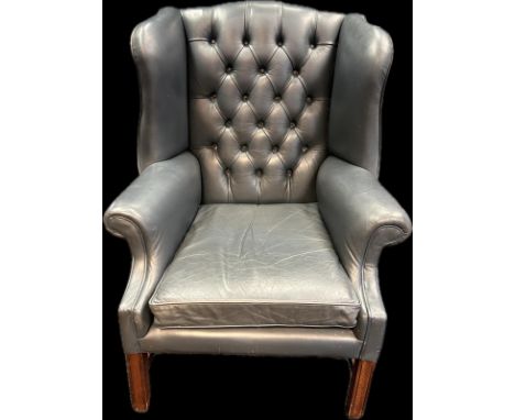 Chesterfield style gull wing chair, covered in a blue button back leather upholstery raised on block legs