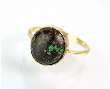 A cabochon boulder opal dress ring, the oval opal collet set in yellow metal to yellow metal shank stamped '18ct', ring size 