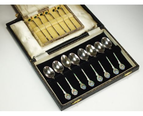 A cased set of eight silver and enamel coffee spoons, Birmingham 1976, the handles with green and blue floral enamel decorati