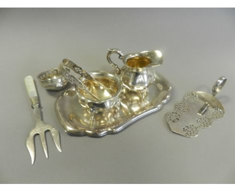 A white metal cream jug and sugar bowl of small proportions together with a white metal tray, a plated toasting fork, a pair 