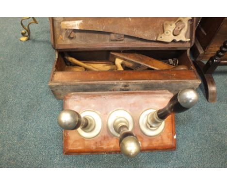 A wood worker's box containing a saw, plane, hammer and various other tools and a mahogany based set of three bar pulls