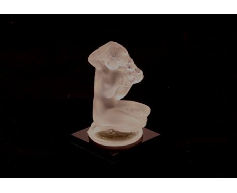 A Lalique glass figure depicting a naked girl with long tresses on a black glass plinth