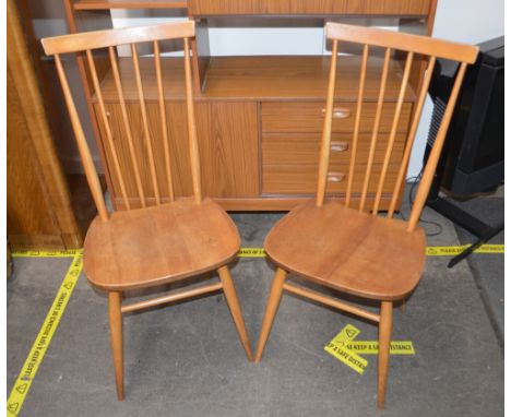 A pair of light elm Ercol type stick back kitchen chairs