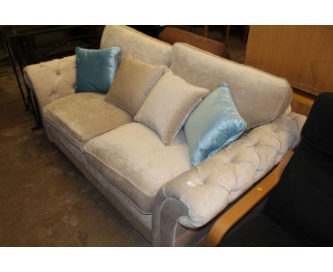 A BUTTON BACK UPHOLSTERED THREE SEATER SOFA