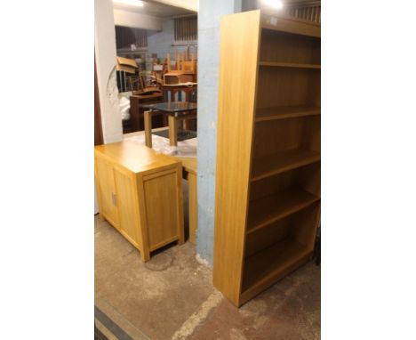 A LARGE LIGHT OAK DINING ROOM TABLE + A GLASS TOP COFFEE TABLE + A LIGHT OAK OPEN FRONTED BOOKCASE + A MODERN TWO DOOR CABINE