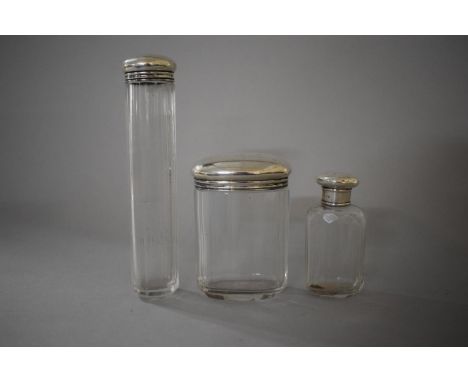 A Collection of Three Silver Topped Glass Dressing Table Bottles 