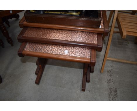 A vintage nest of three teak framed copper top table