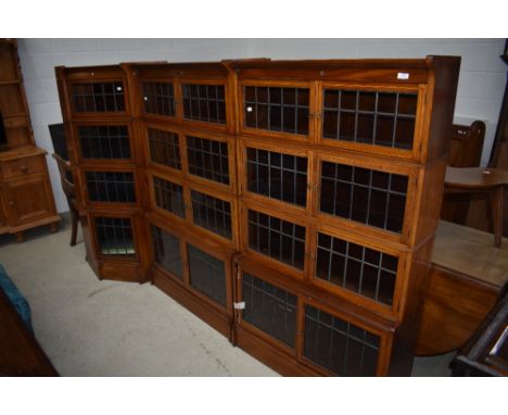 A lovely twelve section run of Edwardian mahogany stacking bookcases comprising two four tier straight sections and a corner 