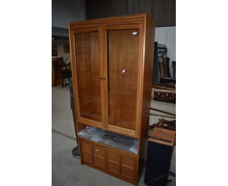 A vintage Nathan teak book/display case having shelf and double cupboard under, width approx. 88cm (Parker Knoll)