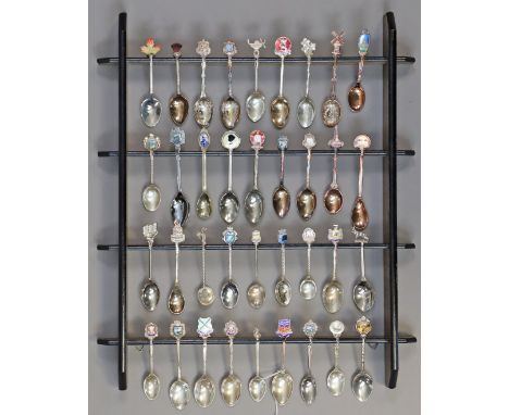 A collection of thirty-six various souvenir teaspoons (including seven silver spoons); with a wooden display shelf. 
