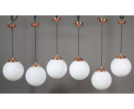 Seven globular opaline glass pendant ceiling lights&nbsp;with copper fittings (each globe 23cm dia.); together with two stack