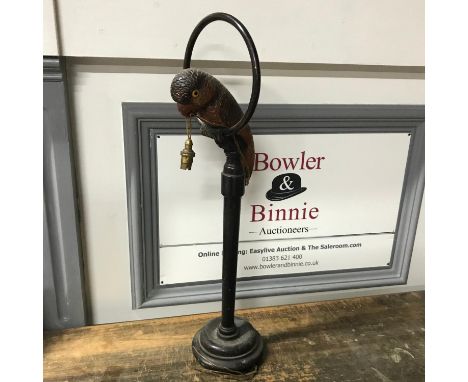 An Art Deco Parrot hand carved table lamp. Black Forest style. Parrot has glass eyes, Sat upon a wooden perch turned support,