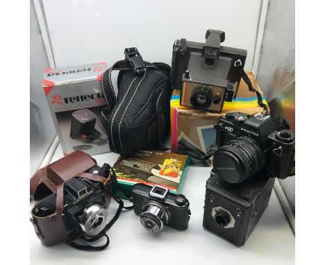 A Collection of vintage cameras and accessories. includes Praktica BX20 Camera, Coronet Cub, Coronet 66 &amp; Polaroid colour