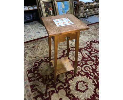 An Arts and crafts light oak plant stand table with fitted tile to the top. 