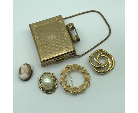 A Ladies vintage KGU Compact/ cigarette case, Two Monet brooches, Gilt metal and carved cameo brooch and one other brooch. 