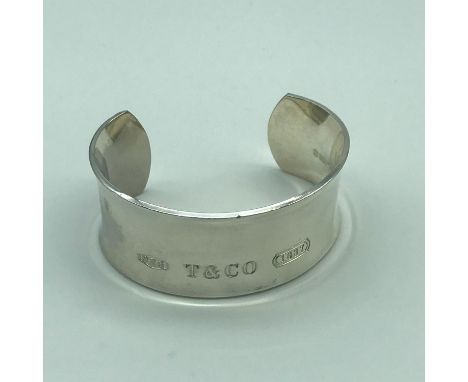 A White metal bangle, Engraved with Tiffany &amp; Co lettering. 