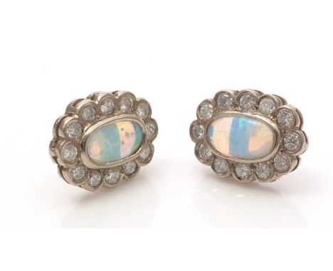 A pair of opal and diamond cluster earrings, the oval opal cabochons each surrounded by twelve brilliant-cut diamonds, in gol