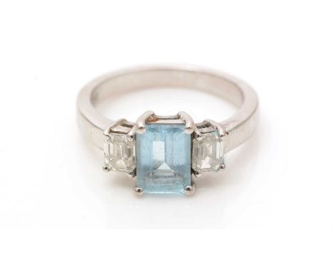 A topaz and diamond ring, the rectangular step-cut light blue topaz flanked by emerald-cut diamonds weighing a total of appro