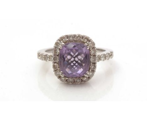 An amethyst and diamond cluster ring, the oval fancy-cut amethyst surrounded by brilliant-cut diamonds, the 18ct white gold s