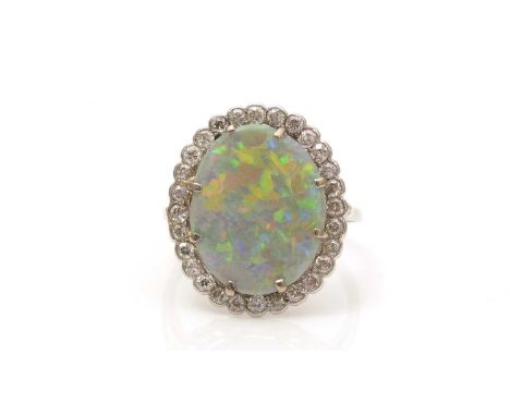 An opal and diamond cluster ring, the oval opal plaque measuring 17.0 x 13.6 x 3.8mm, surrounded by eight-cut diamonds, in pl