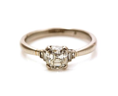 A solitaire diamond ring, the emerald-cut diamond measuring 6.1 x 5.6 x 4.3mm estimated to weigh 1.20 carats, flanked by four