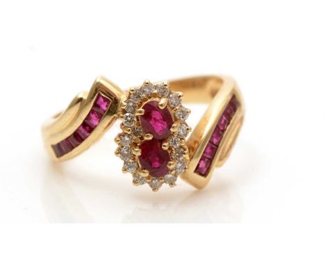 A ruby and diamond double cluster ring, set with two oval facet-cut rubies surrounded by brilliant-cut diamonds and flanked b
