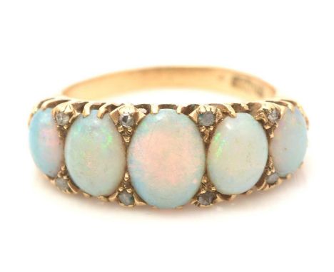 An early 20th Century five stone opal ring, the graduated oval opal cabochons surrounded by rose-cut diamonds, in 18ct yellow