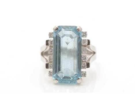 An aquamarine and diamond ring, the canted-rectangular step-cut aquamarine measuring 17.5 x 8.2 x 5.5mm, flanked by twelve br