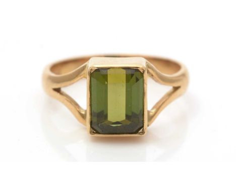 A green tourmaline ring, the canted rectangular step-cut tourmaline measuring 9.9 x 7.1 x 4.4mm, in 18ct yellow gold collet s