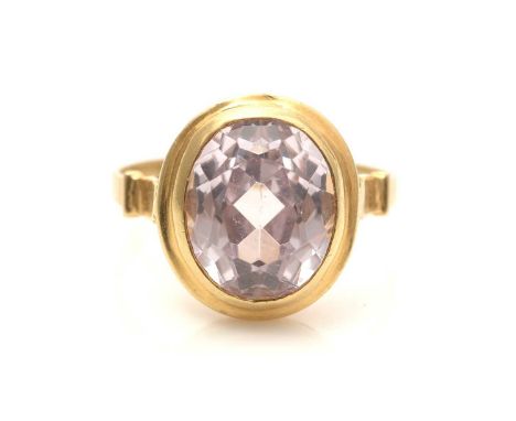 A pale pink sapphire ring, the oval facet-cut sapphire measuring 11.4 x 9.6 x 7.1mm, in 18ct yellow gold collet mount and sha