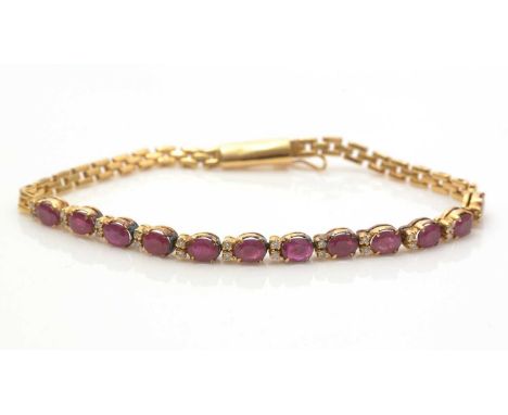 A ruby and diamond bracelet, twelve link set with slightly graduated oval facet-cut rubies and pairs of brilliant-cut diamond