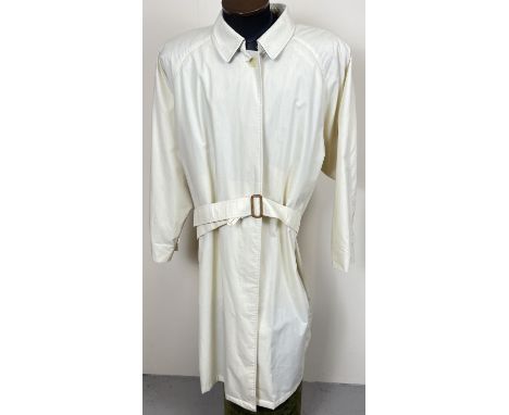 A cream light weight belted trench coat by Burberrys. Front button fastening with 2 front pockets. Button and tab detail to c
