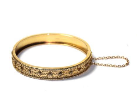 A 15 carat gold hinged bangle with rope twist decoration, to a plain polished hinged back, measures 5.6cm by 4.8cm .  Gross w