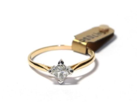 A diamond solitaire ring, the princess cut diamond in a white four claw setting, to a yellow tapered shoulder plain polished 