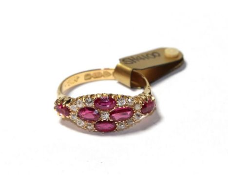 An 18 carat gold synthetic ruby and diamond cluster ring, four oval cut synthetic rubies with an old cut diamond centrally wi