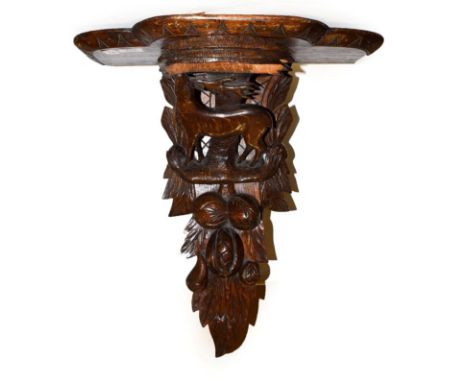 An Edwardian carved oak wall bracket, surmounted by a stag and decorated with leaves, 48cm by 24cm by 56cm 