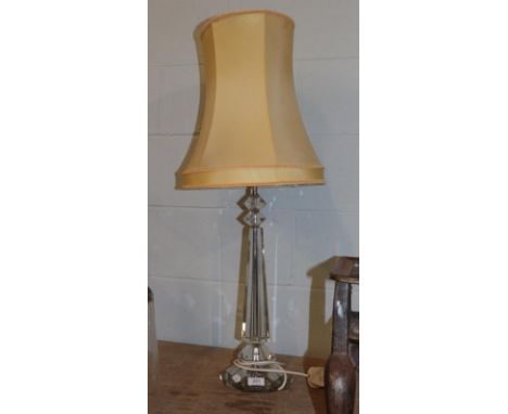 A modern glass based table lamp raised on a faceted plinth, pedestal 55cm