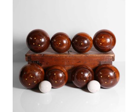 A set of lignum vitae lawn bowls,  the boxed marked 'Shoolbred & Co.'. containing eight turned bowls with ivory inlay, comple