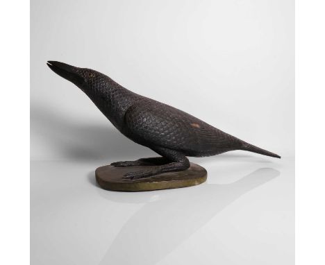 A carved and painted model of a crow, 20th century, Indonesian, modelled with its beak raised, standing on a green plinth,63c