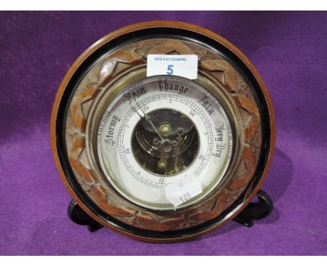 A vintage porthole style barometer with bevel edged glass and visible mechanism
