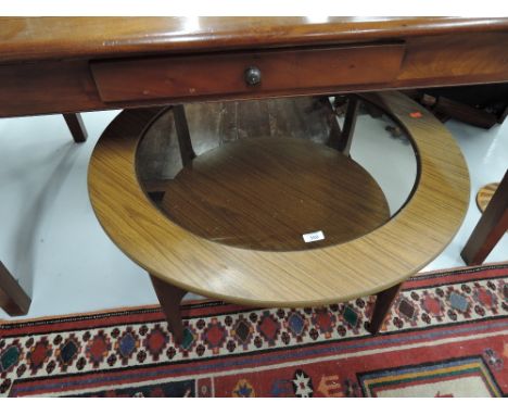 A vintage teak effect and glass circular coffee table