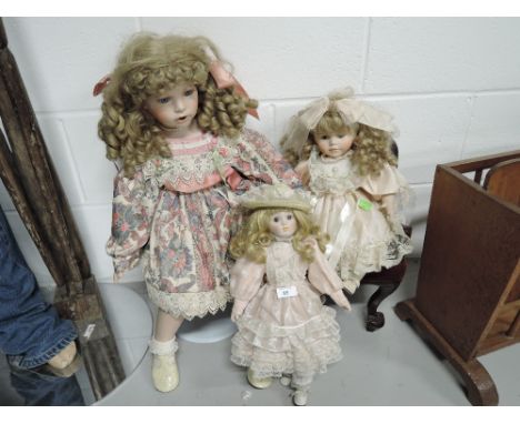 A selection of vintage ceramic head and soft bodied dolls with Sunday dress ware