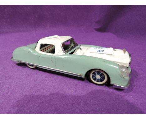 A vintage tin toy car with push along motor play worn