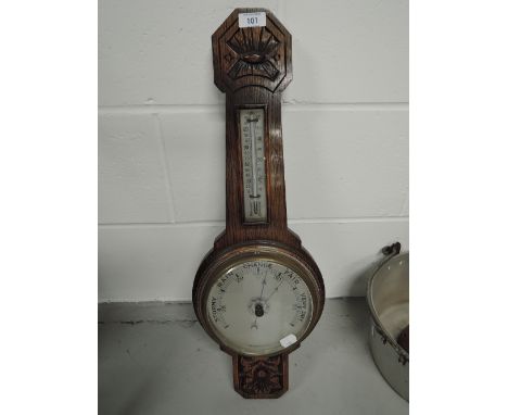 A vintage wall mounted banjo style barometer with carved decoration