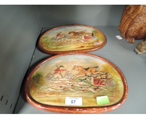 A pair of plaster cast plaques with countryside sports and fox hunting imagry