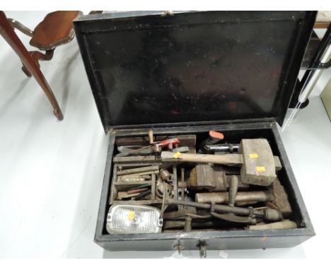 A metal tool box containing a selection of vintage tools including vice, hand drill, mallet etc
