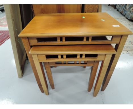A modern nest of three light yew effect tables