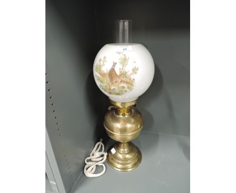 A vintage oil burning gas lamp with milk glass shade and pheasant print