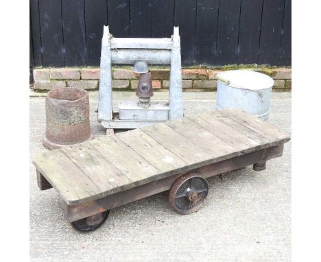 An early 20th century wooden trolley, with iron wheels, 123cm long, together with a cast iron stand, ladder and galvanised it